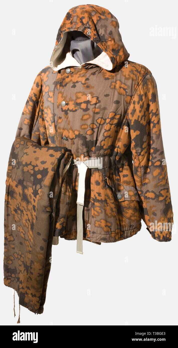 A convertible winter uniform in autumn camouflage, of the Waffen-SS Heavily lined winter jacket with hood, convertible from white to oak leaf pattern autumn camouflage, with slanted reach-through pockets on both sides and a row of buttons with a button-down cover flap. Signs of wear, restored, with small areas of mending and larger areas of patching on the winter side. It comes with matching trousers in the same camouflage. historic, historical, 1930s, 20th century, Waffen-SS, armed division of the SS, armed service, armed services, NS, National Socialism, Nazism, Third Rei, Editorial-Use-Only Stock Photo