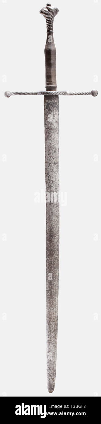 A German hand-and-a-half sword, circa 1520 Heavy blade of lenticular  cross-section and small remnants of brass inlay at the forte. Curved, "S"  shaped, helically grooved quillons with compressed knob finials. Grooved  guard