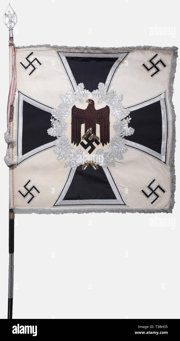 A standard for an infantry battalion, with the flag banderoler White silk with silver fringe on three sides. On both sides a hand-embroidered black army eagle with its feathers set off in brown. Beak and talons rendered in raised gold embroidery, on a field of cream-colored silk, surrounded by a silver-embroidered oak leaf wreath on an iron cross. An applied swastika in each of the corners. Dimensions ca. 125 x 125 cm. Banderole of aluminium fabric with a black/white/red interweave, complete with both clasps, displaying '16. März 1935', and '16. März 1936, No-Exclusive-Use | Editorial-Use-Only Stock Photo