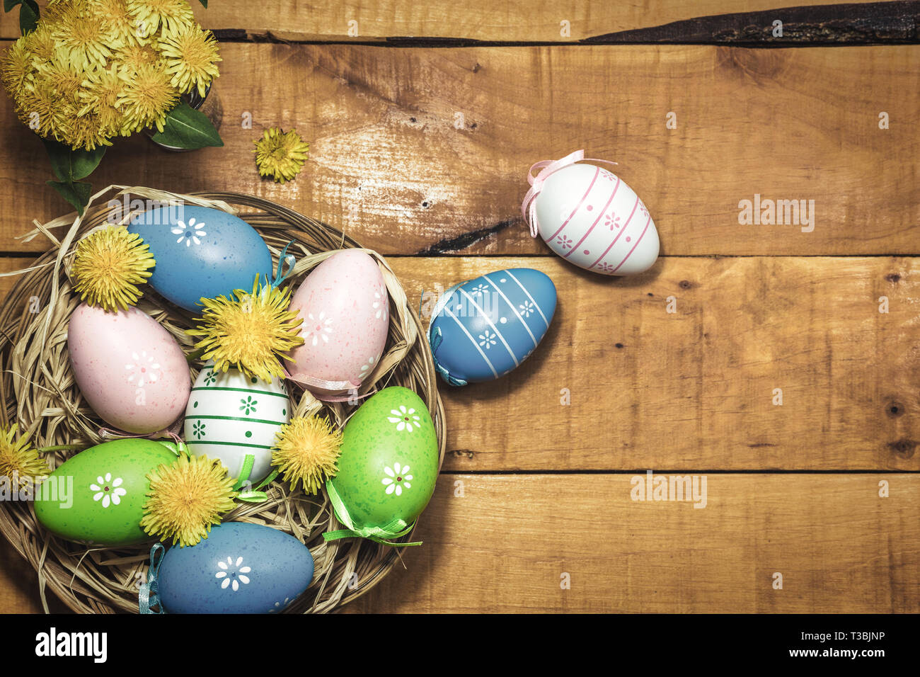 Colorful Easter eggs on wooden background with spring flowers, top view ...