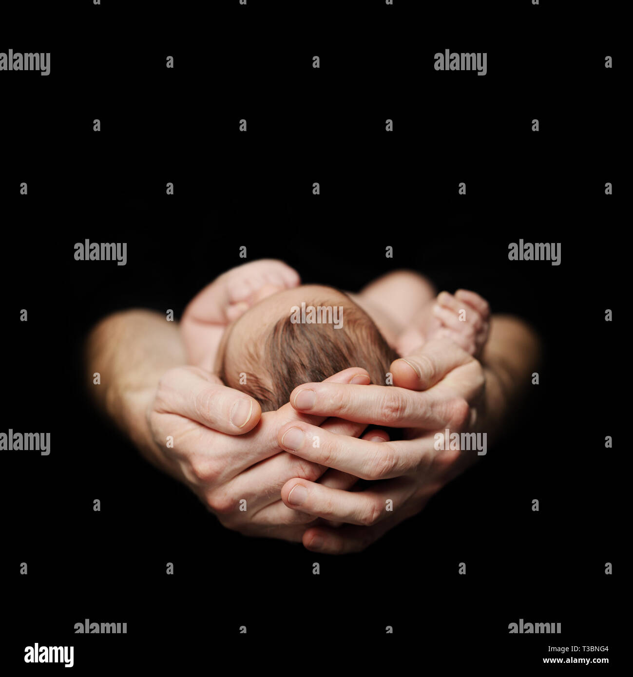Parenthood concept. Newborn baby on father's hand on black background Stock Photo