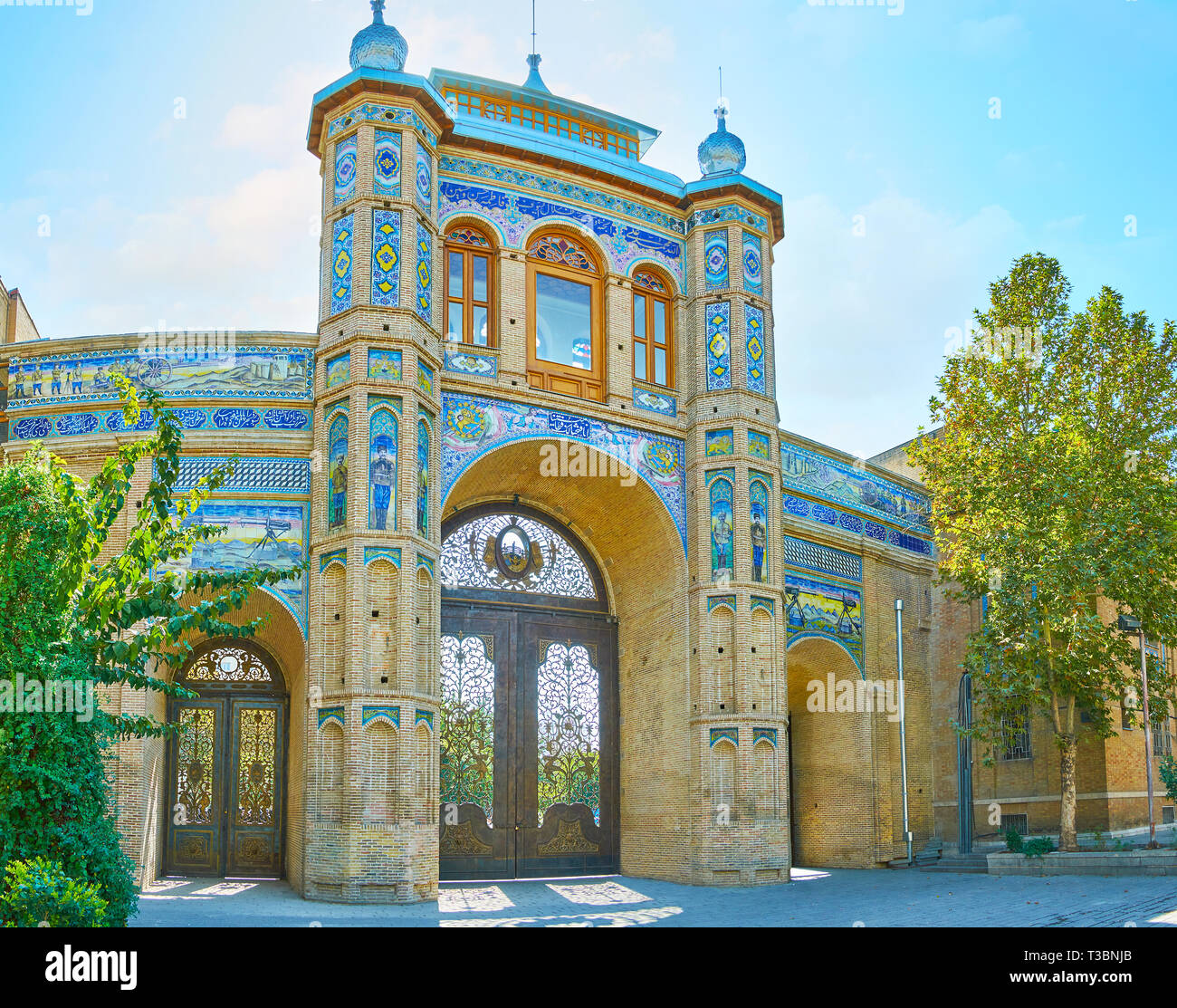 TEHRAN, IRAN - OCTOBER 25, 2017: Panorama of Sardar-e Bagh-e Melli gate of National Garden with brick columns, scenic doors, ornate tilework and Persi Stock Photo