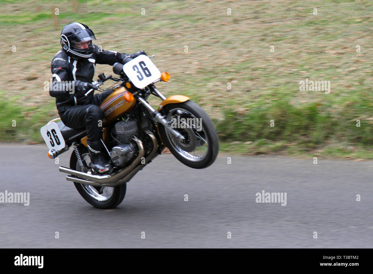 70s vintage bikes at Chorley, Lancashire,Hoghton Tower 43rd Motorcycle Sprint. Rider 36 Tim Jones from Windermere, motorcycle trick, motorbike wheelstand, acceleration, wheelies, stunt, dangerous driving, a wheelie riding an old 1972 749cc Kawasaki 750HT Stock Photo