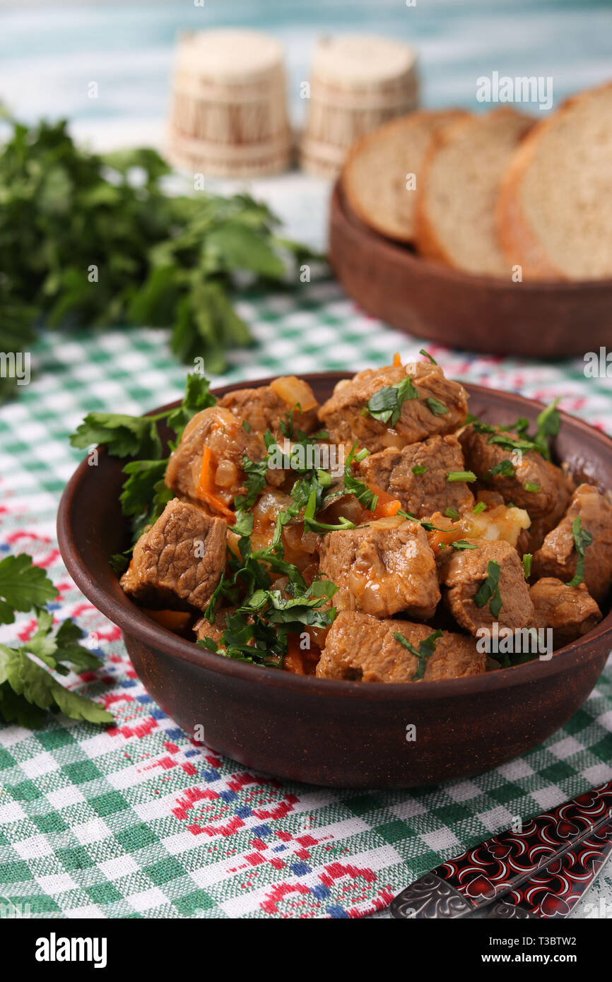 Beef goulash is located in a brown bowl on the table Stock Photo
