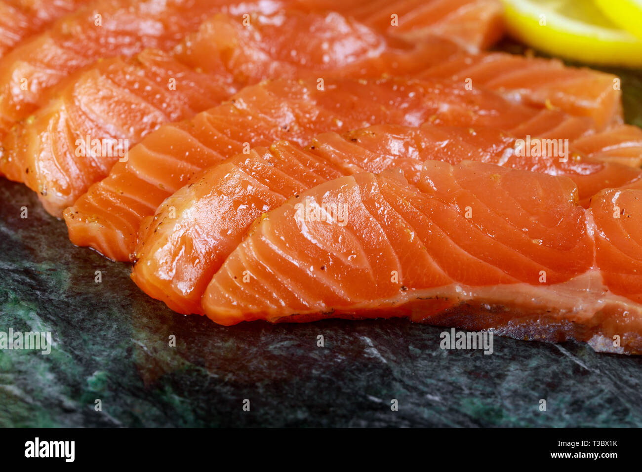 Uncooked salmon fish fillet with avocado, on marble plate, top view