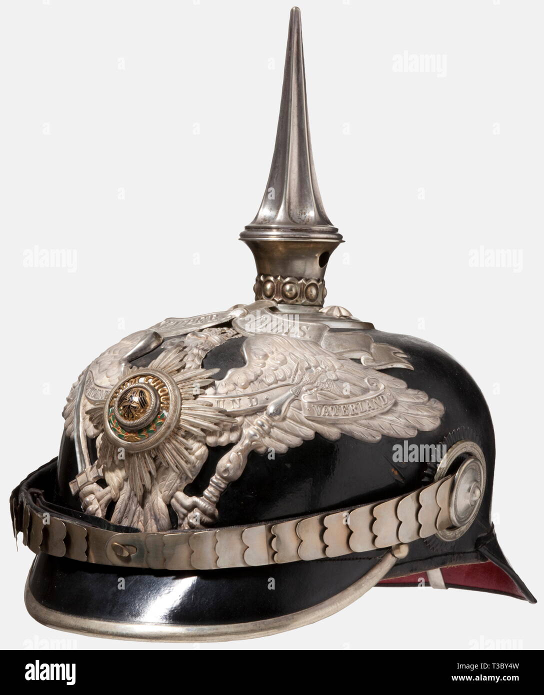 A helmet for officers of the 1st Foot Guards Regiment, Potsdam, circa 1910 A tall officer's helmet in the rare version with the 'SEMPER TALIS' scroll awarded to the 1st Battalion and the regimental staff on 27 January 1889. Black lacquered leather body. Partially frosted and polished silver-plated mountings. Circular crown plate with a fluted spike. Guards eagle with a strongly cambered, enamelled guard star. Silver-plated flat metal chinscales on silver-plated rosettes. Both cockades. Light-coloured sweatband and ribbed silk lining (loose in bac, Additional-Rights-Clearance-Info-Not-Available Stock Photo