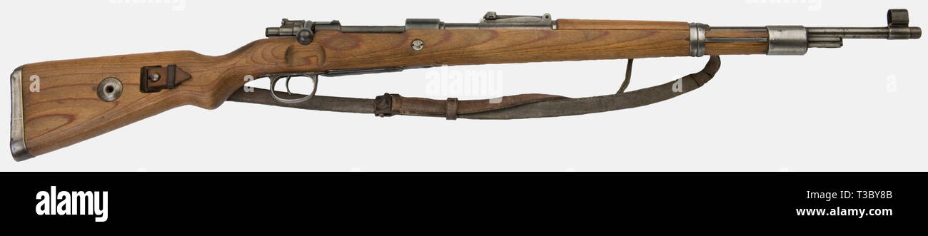 A Mauser 98k carbine, stamped 'bcd' on top of the receiver, made by Wilhem Gustloff Werke Weimar in 1943, caliber 7,92 x 57, number 3460gg (not matching bolt number 6656). Laminated stock, milled upper band, welded trigger guard, with its leather sling, cleaning rod missing, original bluing. historic, historical, 1930s, 20th century, firearm, fire arm, gun, fire arms, firearms, guns, weapon, arms, weapons, arms, object, objects, stills, clipping, clippings, cut out, cut-out, cut-outs, Editorial-Use-Only Stock Photo