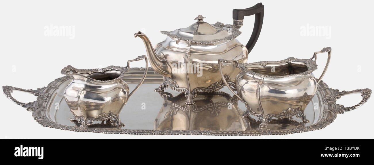 A silver tea service, James Dixon & Sons, Sheffield, circa 1900 Sterling silver. Service consisting of a tray, tea pot, sugar bowl and creamer. The vessels in a curved shape with lavishly profiled rims, English baroque style. All parts with English hallmarks and manufacturer's mark Dixon & Sons, next to it importer's stamp "Gebr. Friedländer" (Berlin) and German mark of fineness "925". Width of the tray 60.5 cm, total weight 3980 g. historic, historical, 1900s, 20th century, 19th century, handicrafts, handcraft, craft, object, objects, stills, cl, Additional-Rights-Clearance-Info-Not-Available Stock Photo