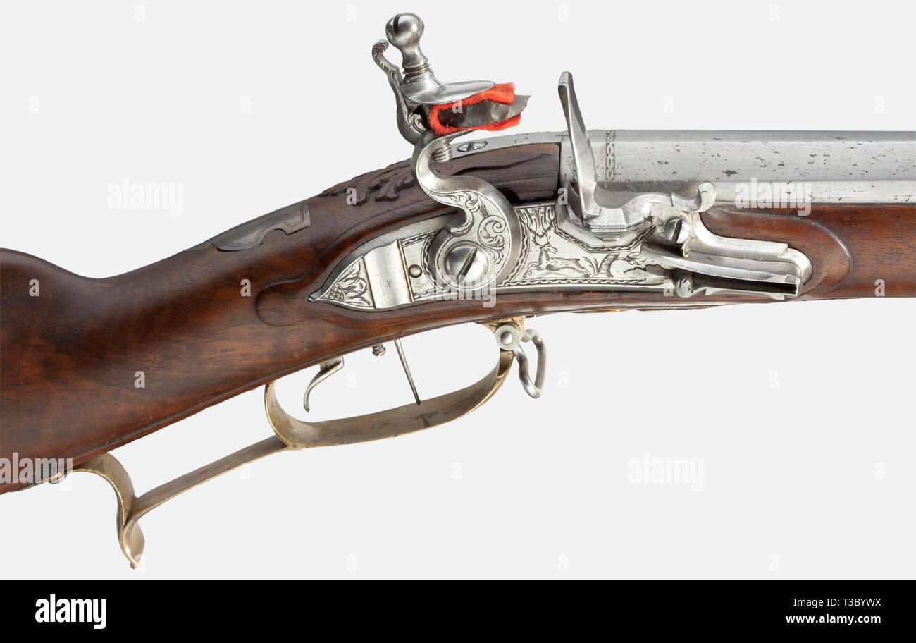 A flintlock rifle, German, 1730/40. Octagonal rifled barrel in 14 mm calibre. Brass front sight and folding rear sight. The chamber and muzzle are modestly engraved. The tang is inscribed '12'. Flintlock engraved with hunting themes. Adjustable set trigger. Walnut full stock with brass furniture decorated with scrollwork. Silver escutcheon. Patchbox. Wooden ramrod with horn tip. Length 109 cm. Provenance: Christie's, Bedeutende Europäische Waffen, Dusseldorf 1972, lot 101. historic, historical, 18th century, civil long guns, gun, weapons, arms, w, Additional-Rights-Clearance-Info-Not-Available Stock Photo