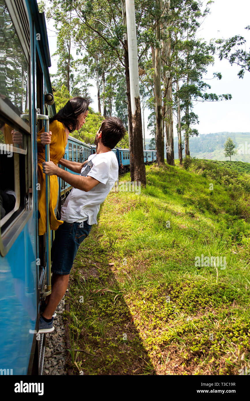 Loving couple hanging outside of train in Sri Lanka Stock Photo