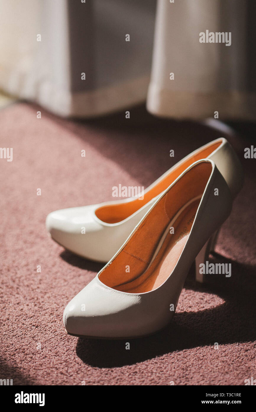 Elegant white wedding shoes on the table Stock Photo