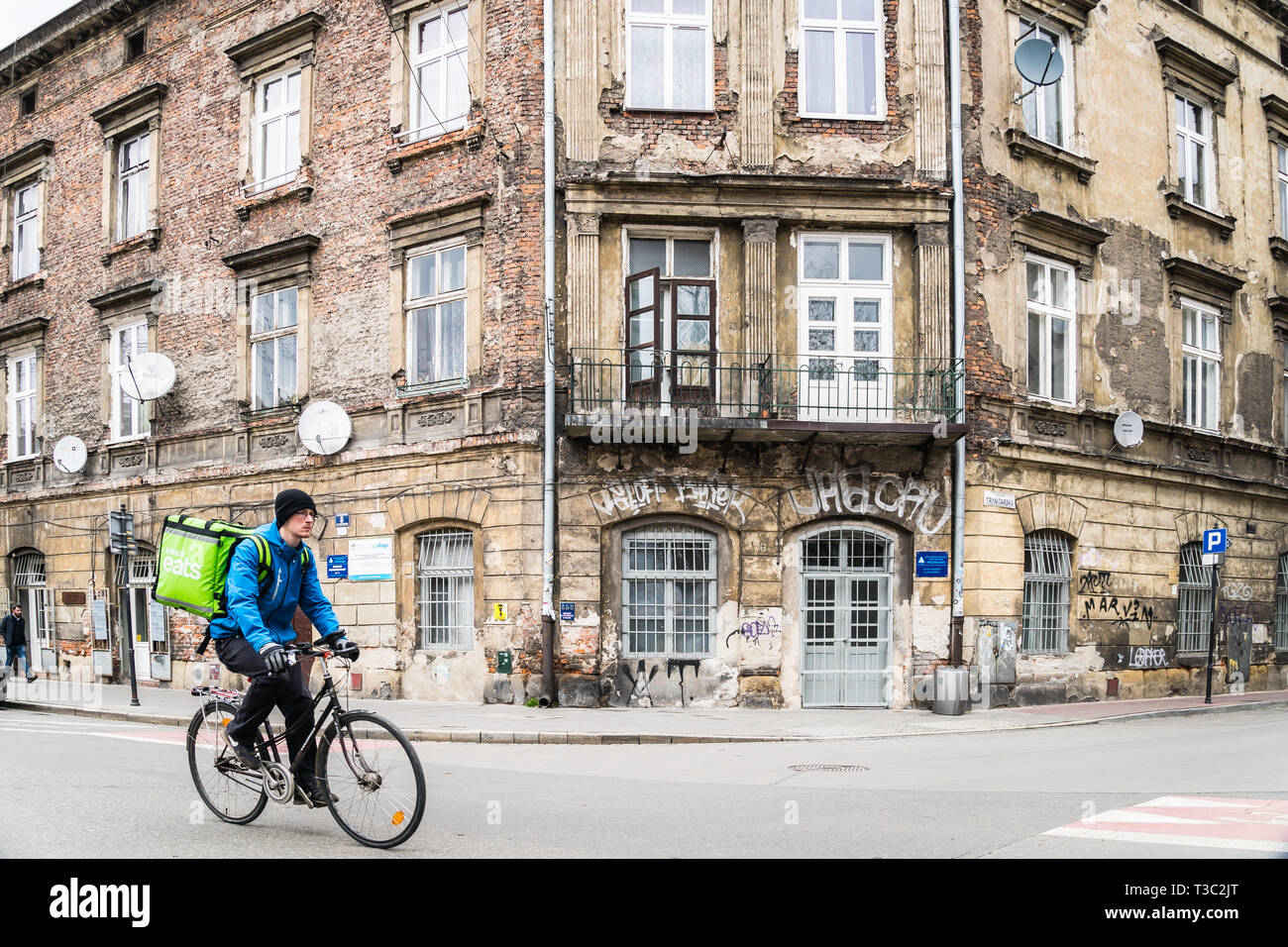 Krakow, Poland - March 22, 2019 - Uber eats delivery man in a cycle on an old town street Stock Photo