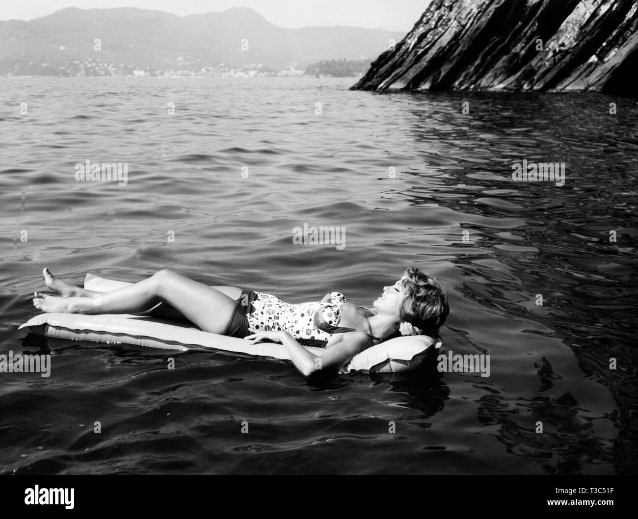 woman on airbed, lake, 1962 Stock Photo