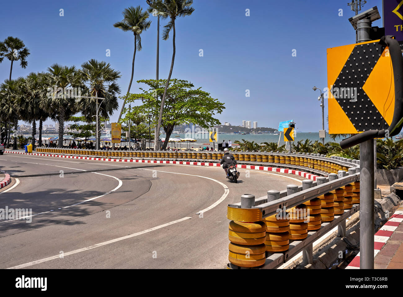 Motorcyclist navigating a sweeping bend with crash barriers protection, Pattaya, Thailand, Southeast Asia Stock Photo