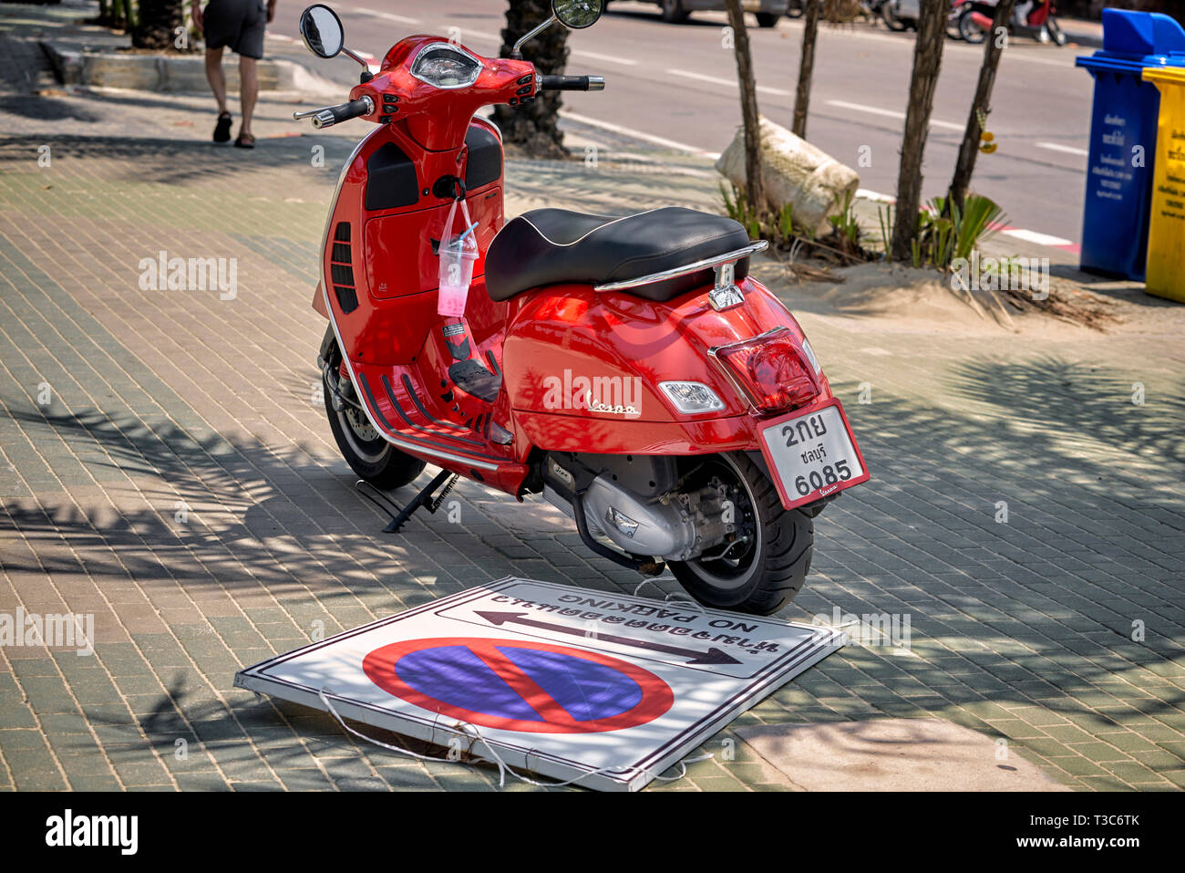 Illegal parking. Motorbike parked on the pavement having also demolished the no parking sign. Thailand, Southeast Asia Stock Photo