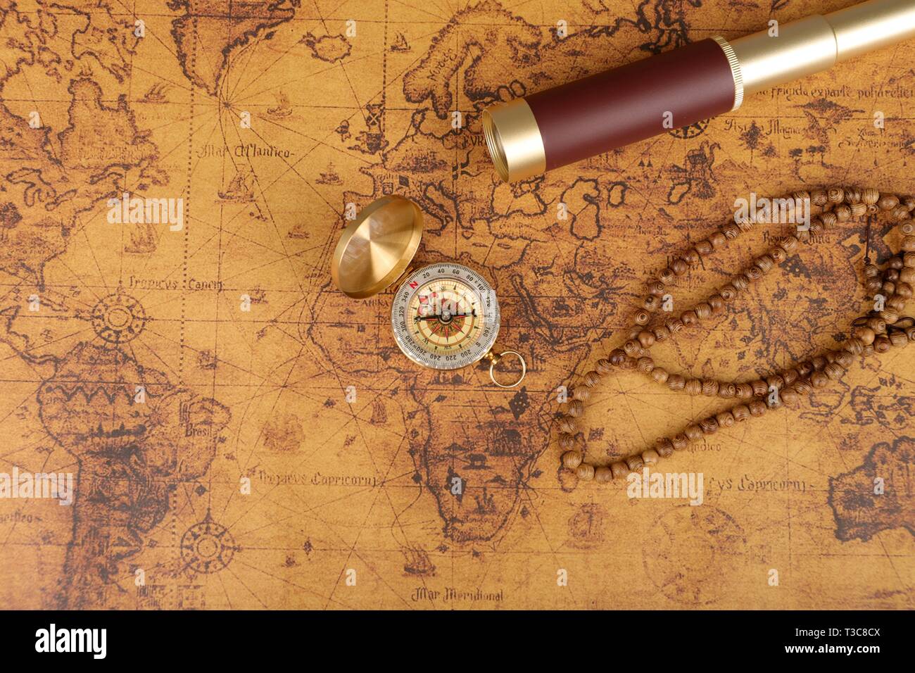 Vintage compass and spyglass on old world map - adventure stories ...
