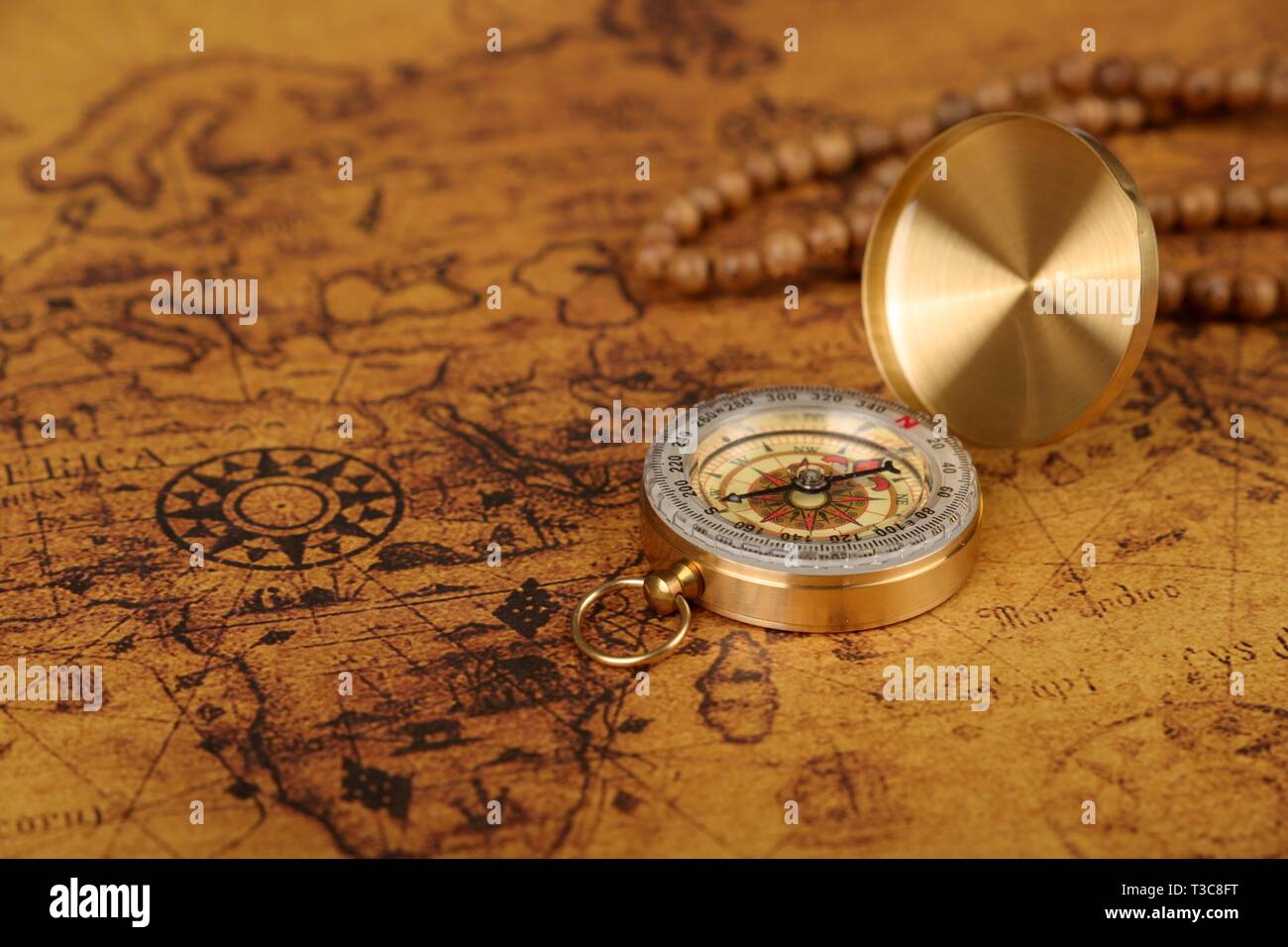 Vintage Compass lies on an ancient world map - adventure stories ...