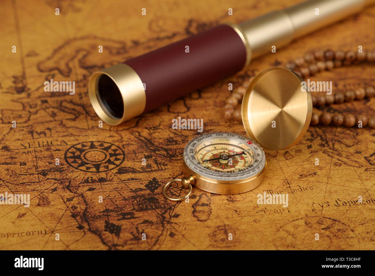 Vintage compass and spyglass on old world map - adventure stories ...