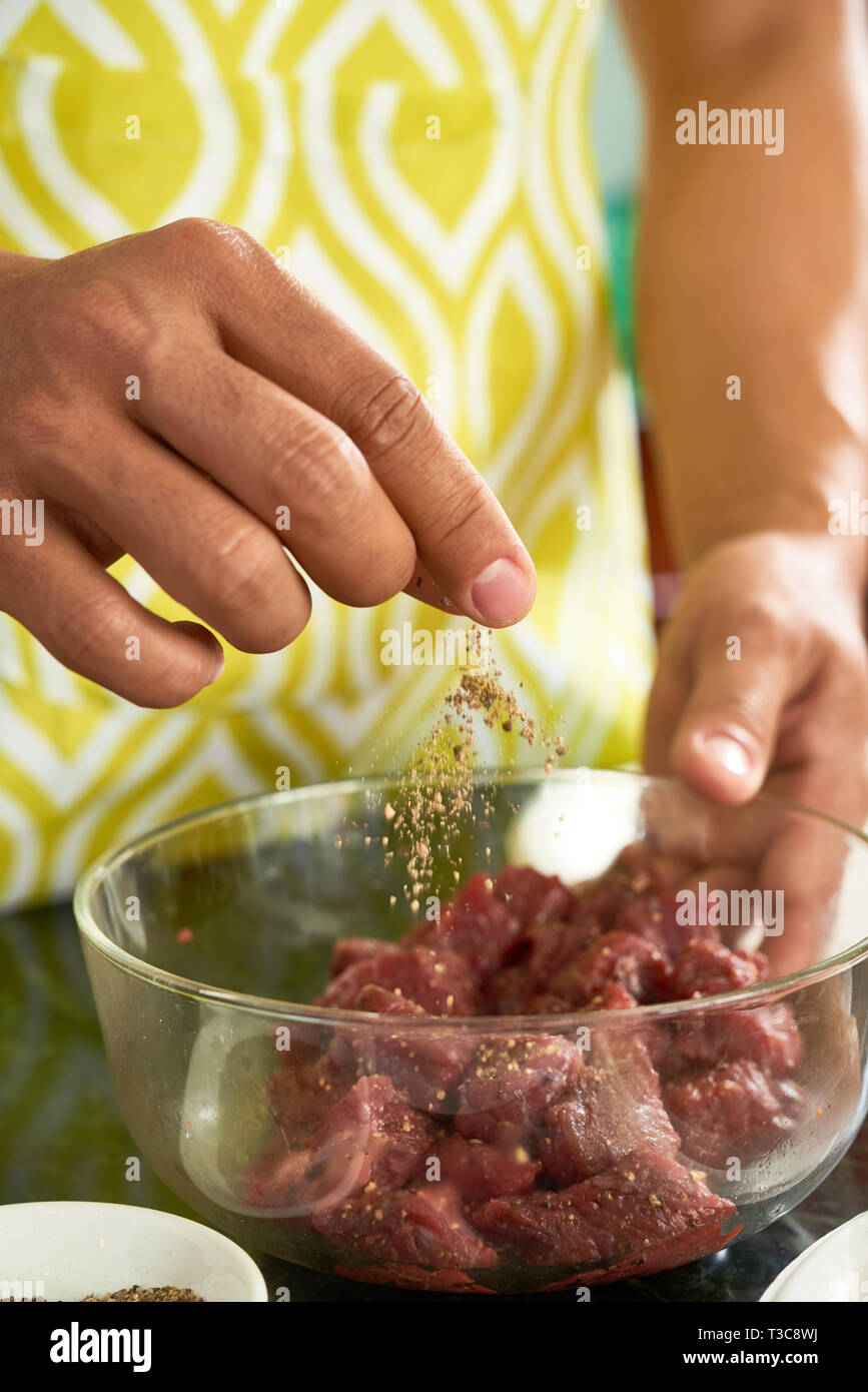 Man seasoning cut meat Stock Photo