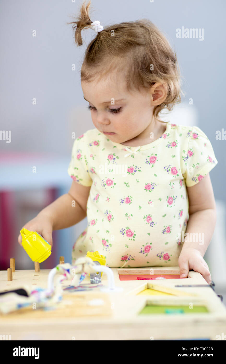 Adorable little girl playing educational toy in nursery Stock Photo - Alamy