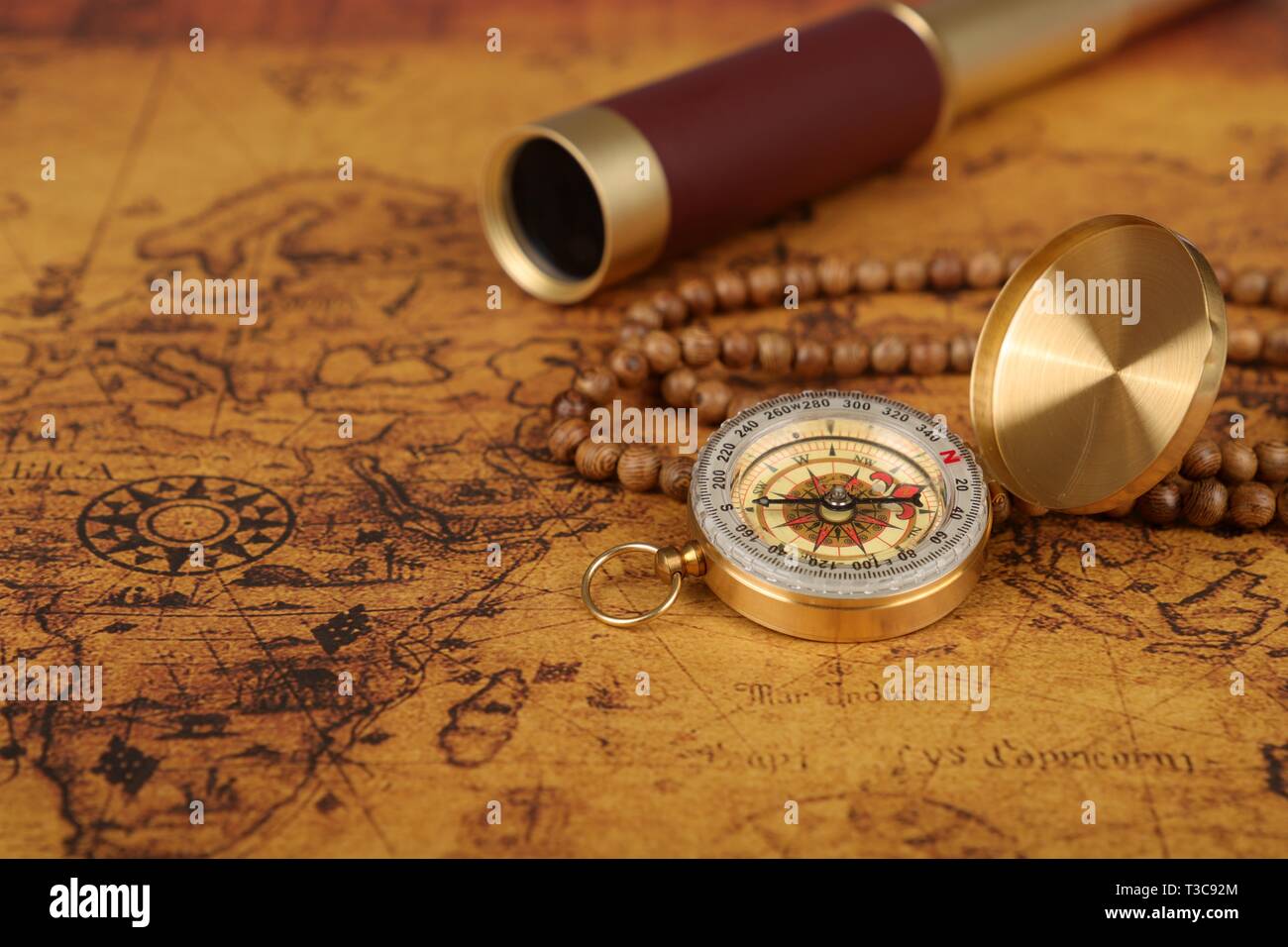 Vintage compass and spyglass on old world map - adventure stories ...