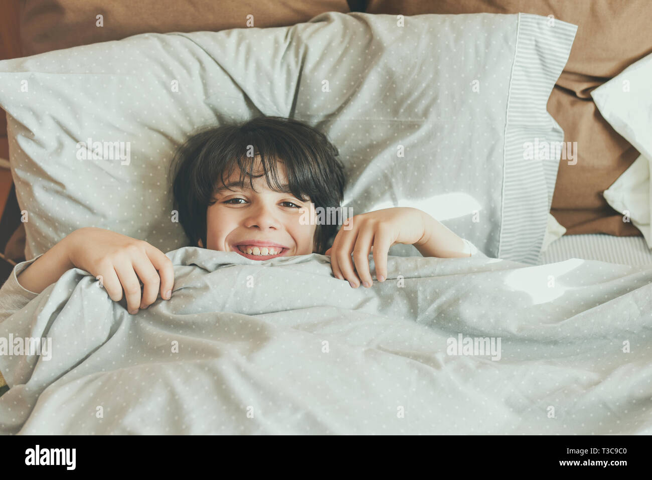 happy child lying on the bed after wake up Stock Photo