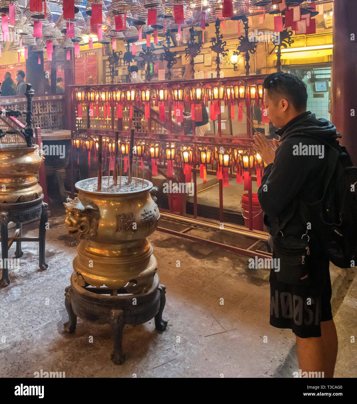 A worshipper in Man Mo Temple, a Taoist temple on Hollywood Road, Sheung Wan, Central district, Hong Kong Island, Hong Kong, China Stock Photo