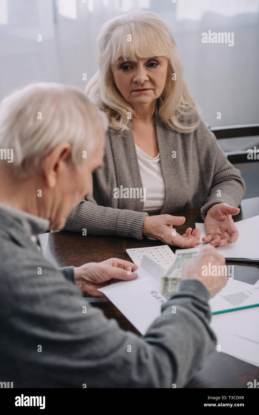 senior couple having discussion while sitting at table with paperwork Stock Photo