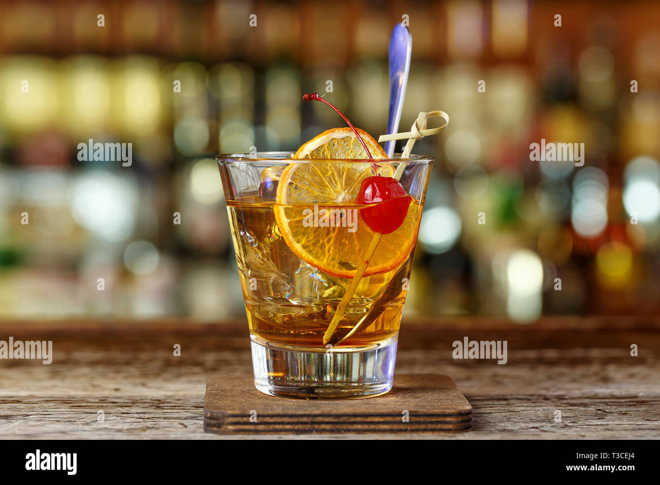 Classic, American cocktail old-fashioned standing on a wooden bar in a restaurant Stock Photo