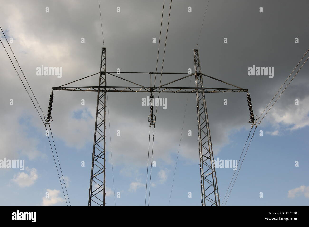 Power lines against cloudy sky Stock Photo - Alamy