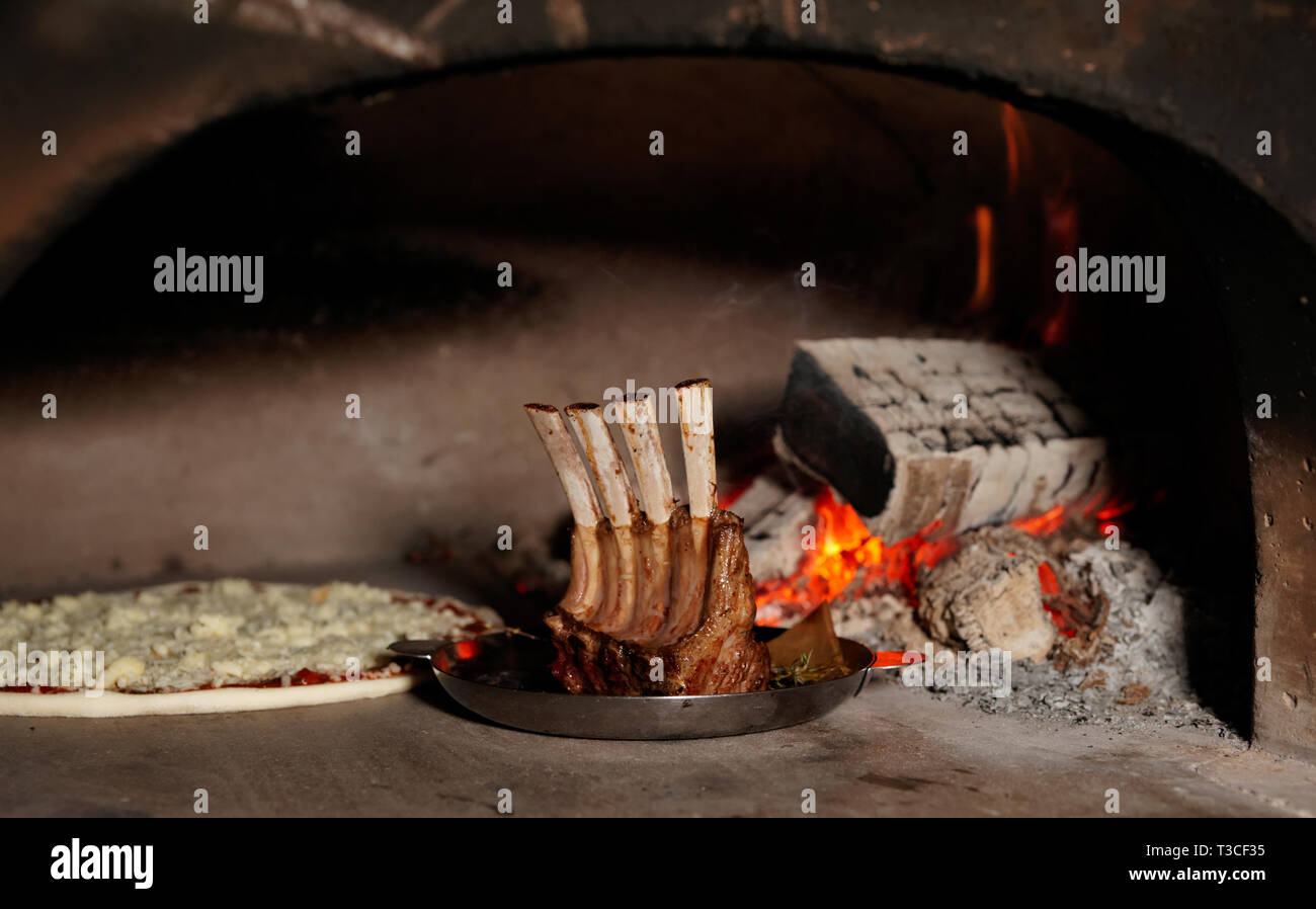 Rack of lamb and pizza in traditional wood fire oven Stock Photo Alamy