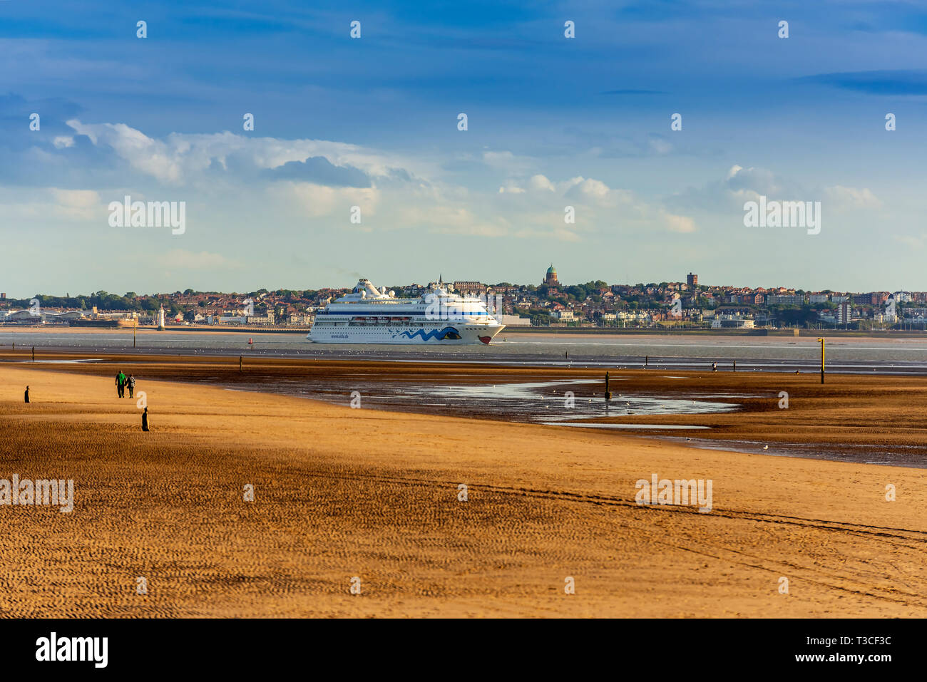 Cruise ship Aida Cara leaves the river Mersey on the evening tide. The town of New Brighton forms the backdrop. Stock Photo