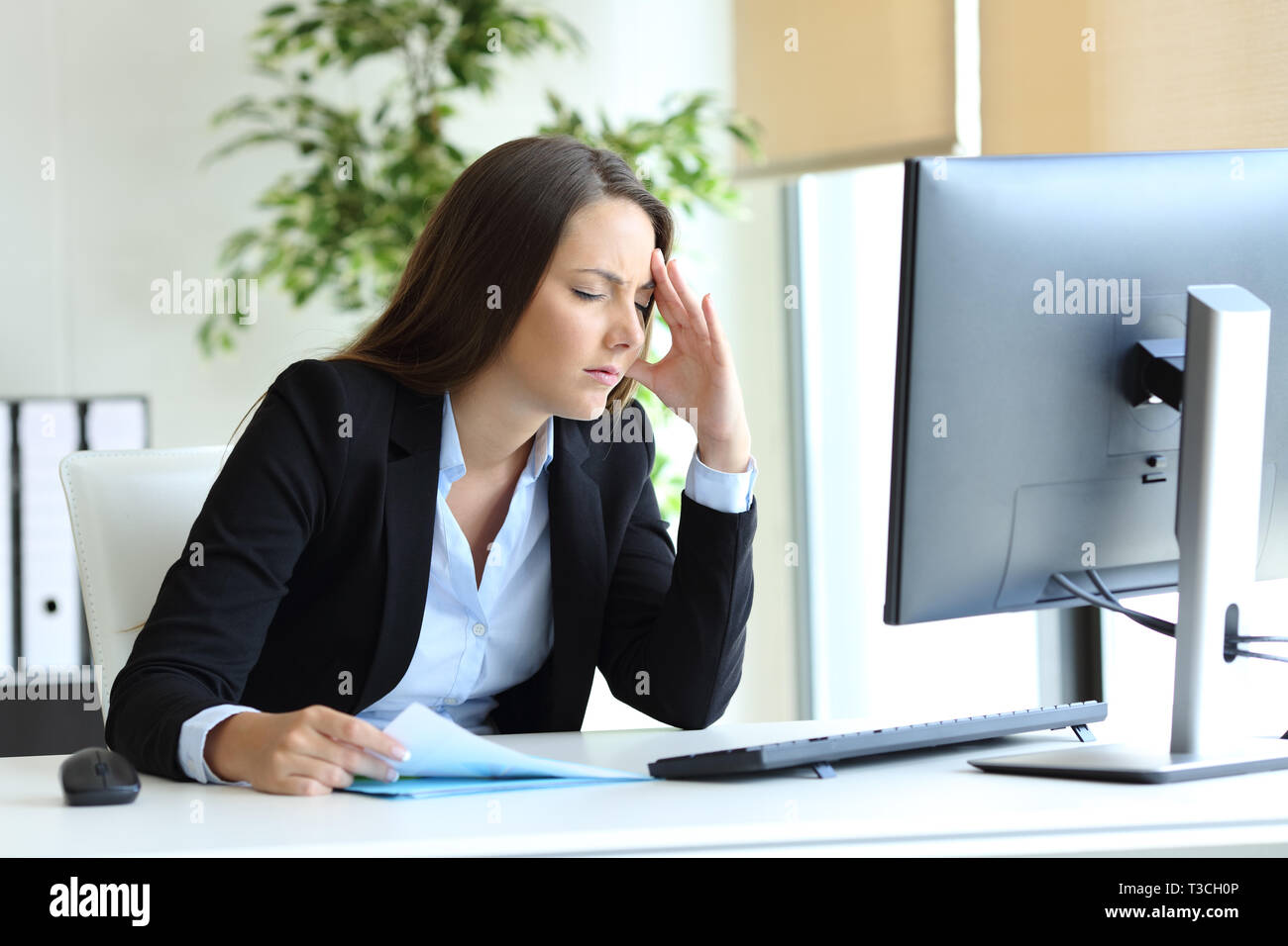 Worried office worker suffering headache and complaining at workplace ...