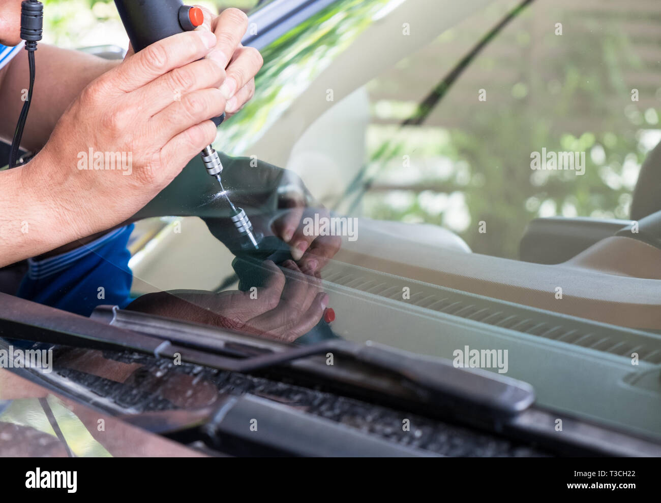 Glazier using tools repairing to fix crack windshield Stock Photo