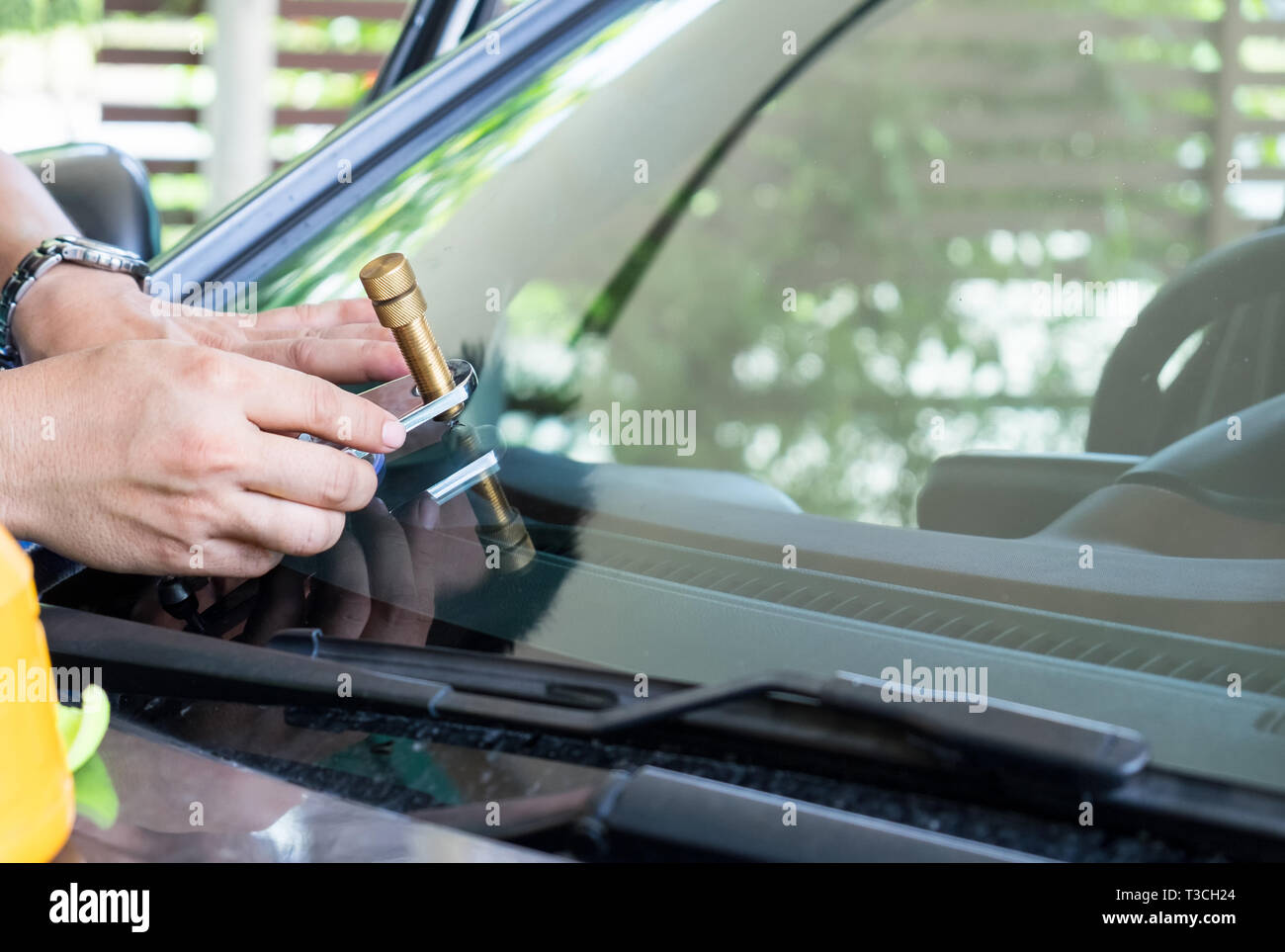 Glazier using tools repairing to fix crack windshield Stock Photo
