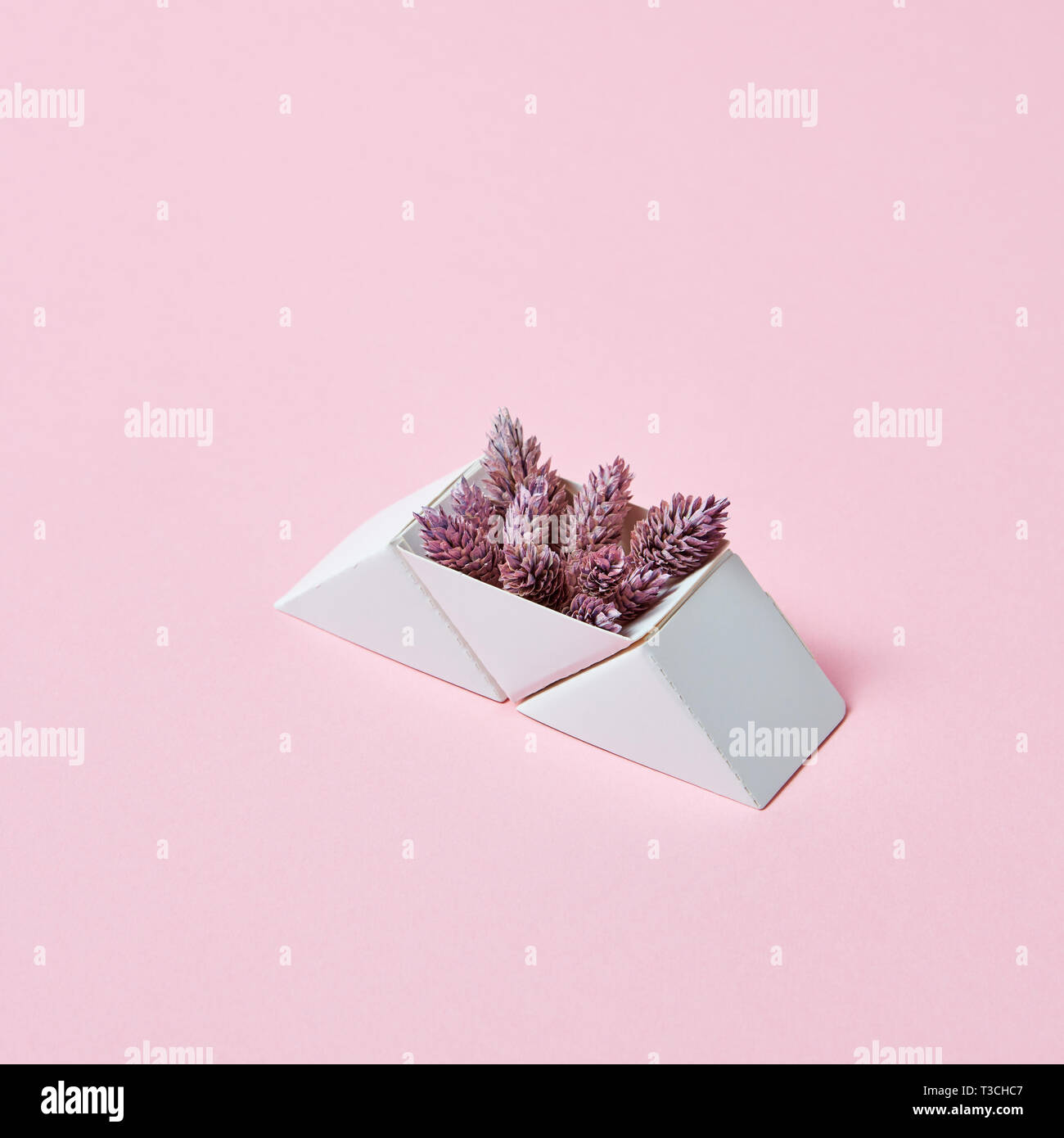 Composition of paper triangular boxes with cones on a pink background ...