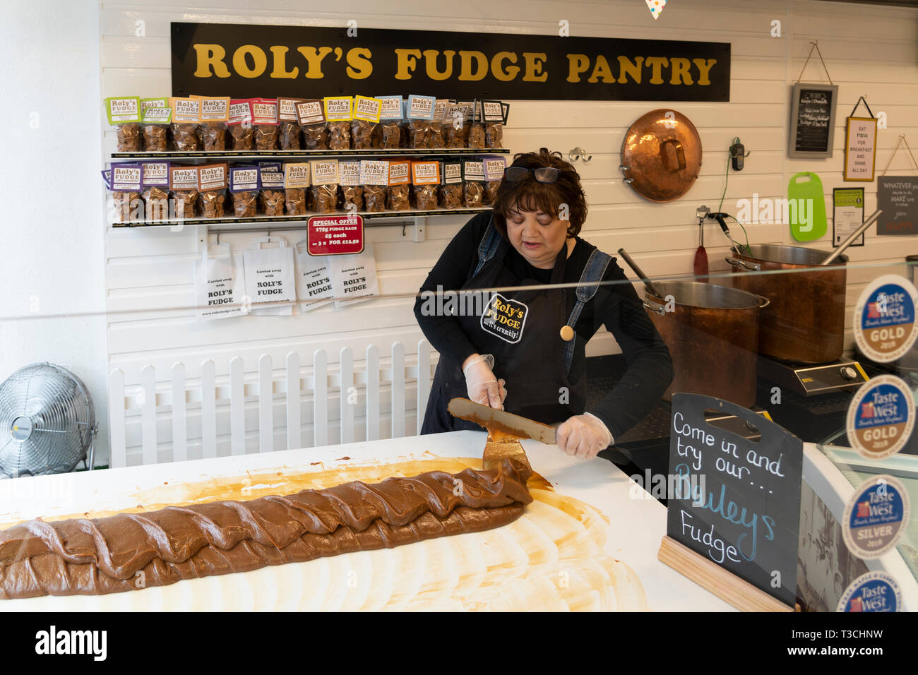 A fudge maker in Roly's Fudge Pantry in Stratford upon Avon making fudge in the traditional method by stirring the fudge with a paddle Stock Photo