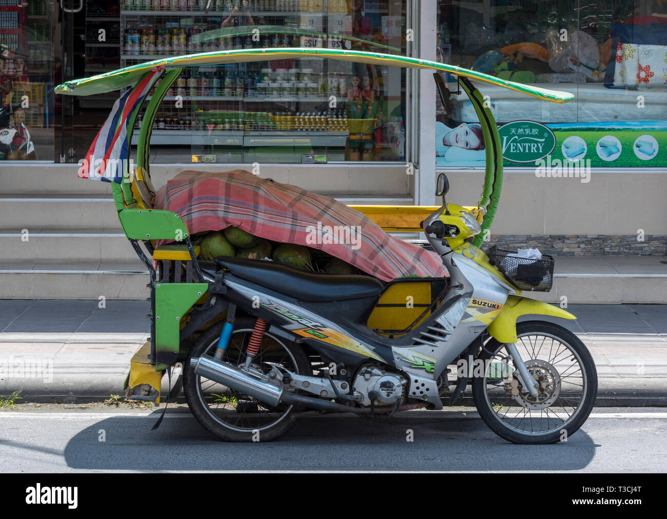 a motorcycle, motorbike and scooter moped with a sidecar being used as a taxi for carrying goods and people as a form of public transport in Bangkok. Stock Photo