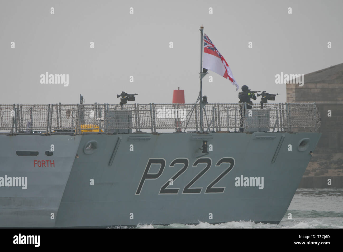 A sailor from the crew of HMS Forth appears to be checking the telescopic sight on his SA80 assault rifle as the ship leaves Portsmouth, UK on 8/4/19. Stock Photo