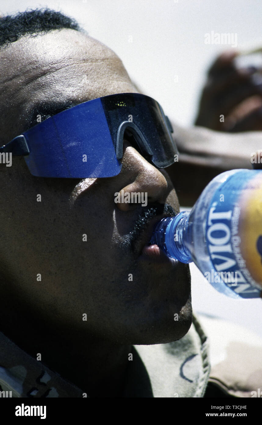 30th October 1993 A black U.S. Army soldier of the 24th Infantry Division, takes a drink of water having just arrived by ship in Mogadishu’s new port, Somalia. Stock Photo