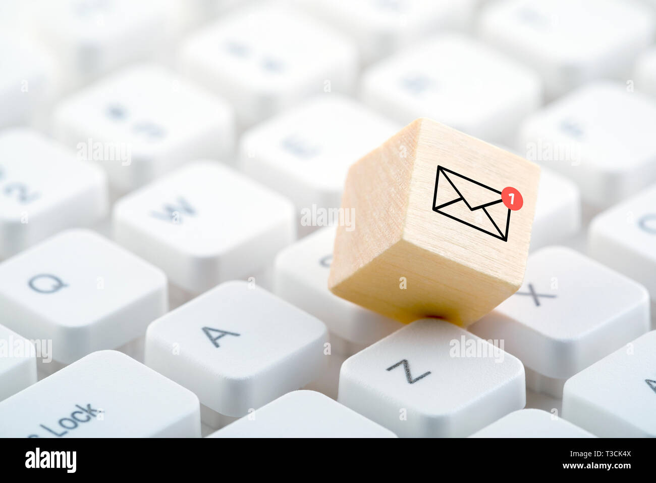 New email graphic on wooden block over computer keyboard Stock Photo