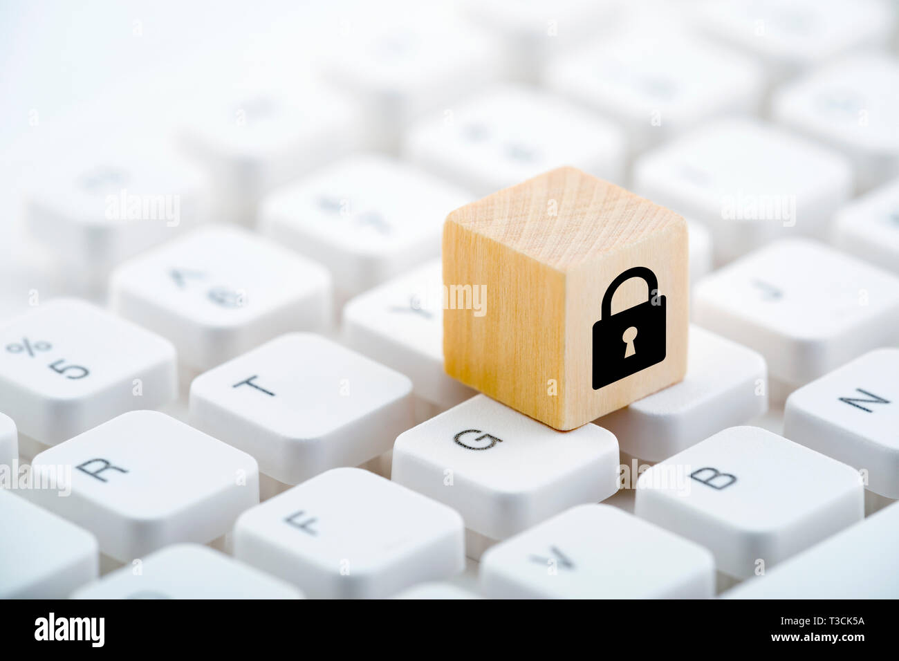 Wooden block with lock graphic on computer keyboard. Computer security