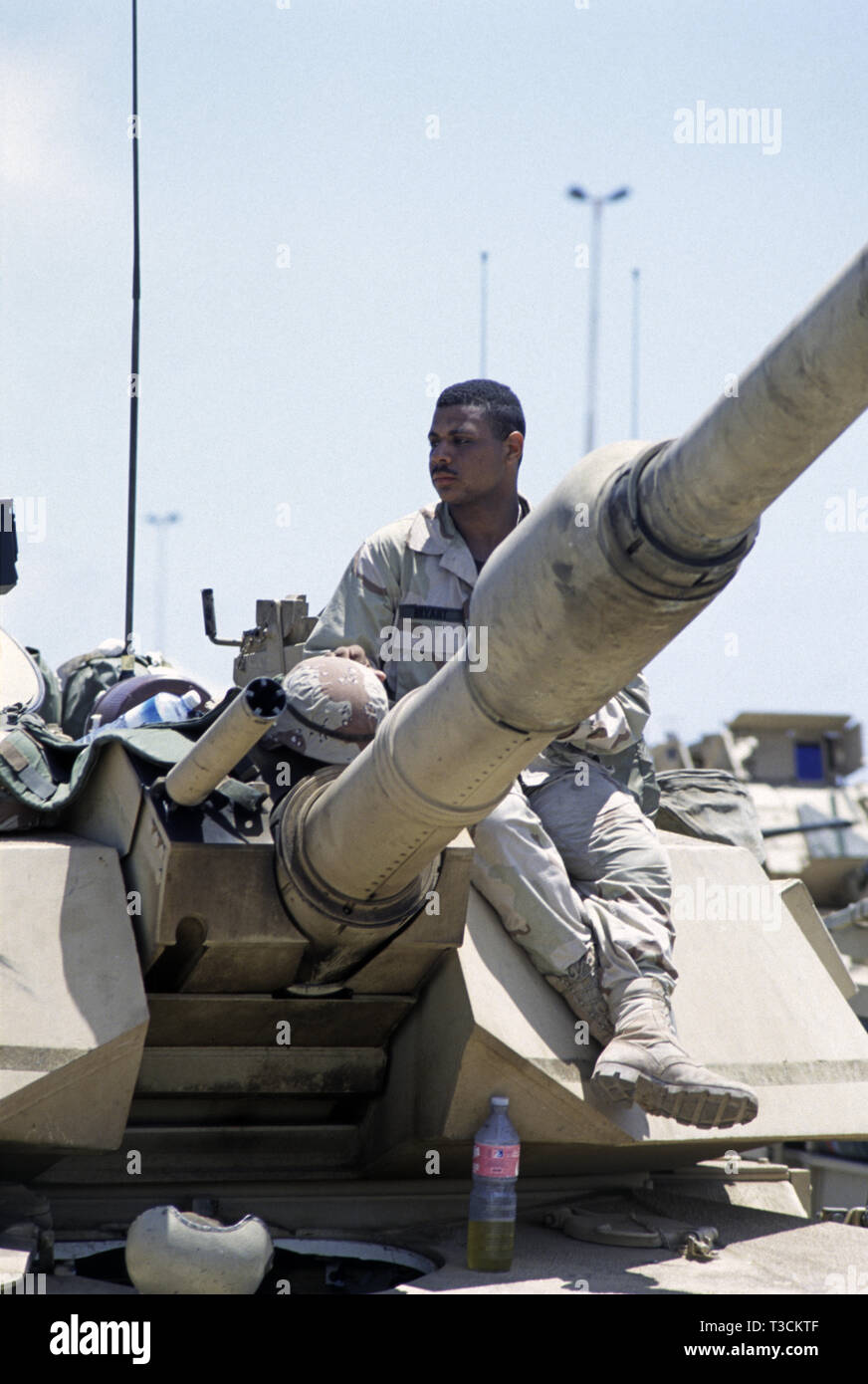 30th October 1993 A black U.S. Army soldier of the 24th Infantry Division, 1st Battalion of the 64th Armored Regiment, relaxes on the turret of his M1A1 Abrams tank in the new port in Mogadishu, Somalia, having just arrived by sea that morning. Stock Photo