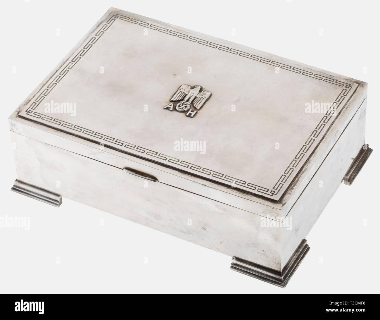 Adolf Hitler, a silver cigar case from his personal silverware Silver, polished surface, in the centre of the lid an applied national eagle with Hitler's monogram 'A.H.', continuously engraved band of meander, three-stage feet. On the bottom the jeweller's mark 'FHW' for Franz and Hermann Wandinger and hallmark '925' next to crescent and crown. The inner lining is made from finely grained wood. Height 7, width 22.5, depth 15.5 cm, weight 1237 g. The brothers Franz and Hermann Wandinger, working in Munich and Dorfen, also forged, apart from parts of his personal silverware, , Editorial-Use-Only Stock Photo