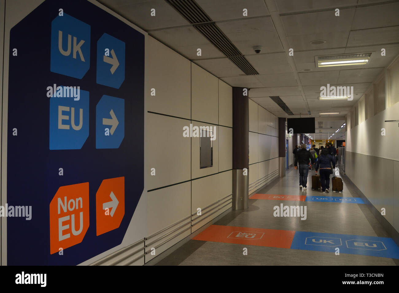 A photograph of air passengers walking past a UK and EU arrivals sign at Gatwick Airport on the original 'Brexit day', 29th of March 2019. Stock Photo