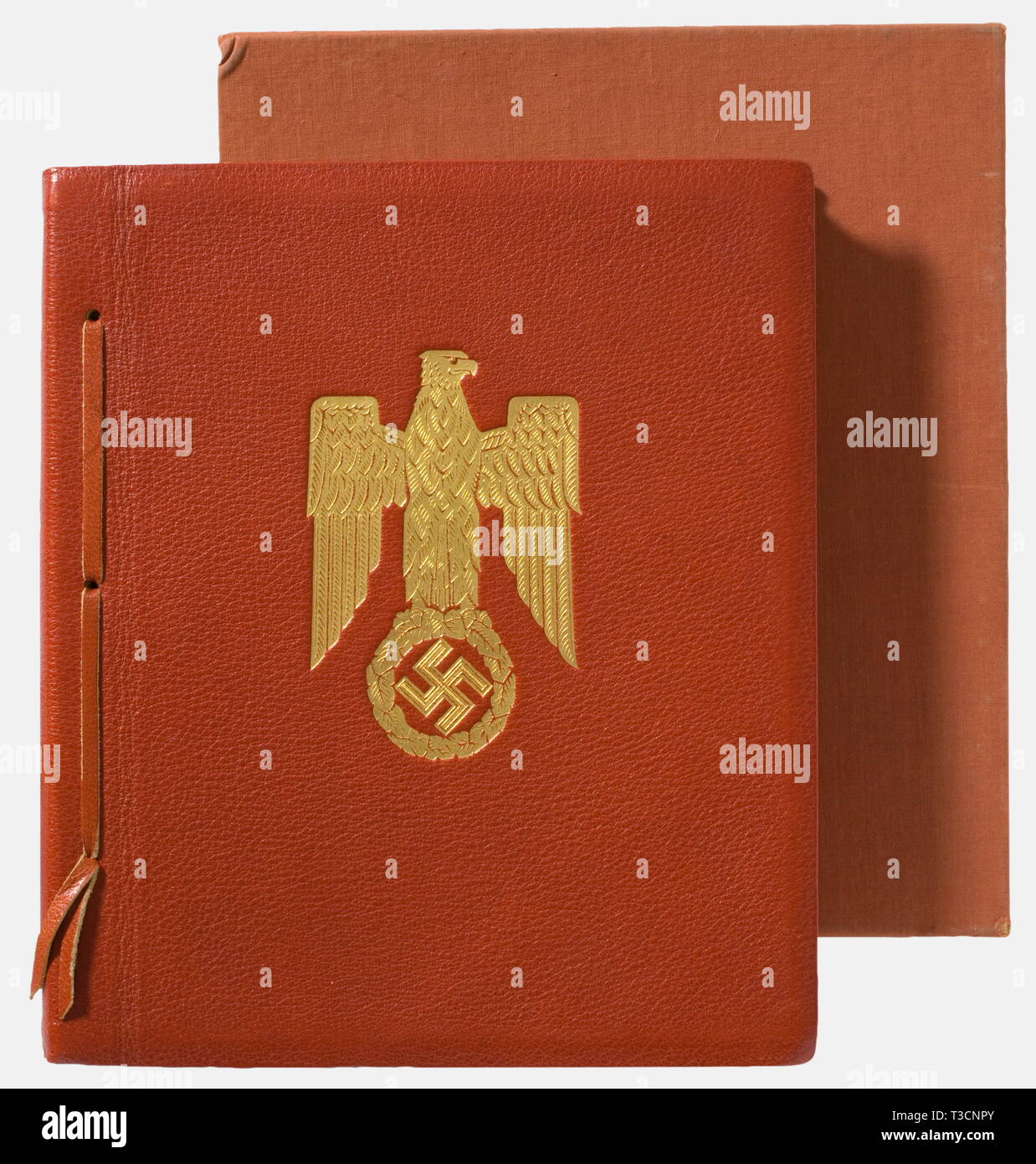 Adolf Hitler, an illustrated book from the library of the Reich Chancellery, given as a gift on the occasion of Benito Mussolini's visit 'Munich, the capital of the movement, welcomes Benito Mussolini' on the flyleaf, gold-stamped national eagle on the red leather cover, German and Italian text printed on parchment, black and white photo section and colour sketches by Prof. G. Buchner of the flag decoration in Munich. Design and layout by Max Schmidt & Söhne, Munich. With slipcase. The cover (slightly bent) with gold-stamped ex libris 'Library of the Reich Chancellery' on t, Editorial-Use-Only Stock Photo