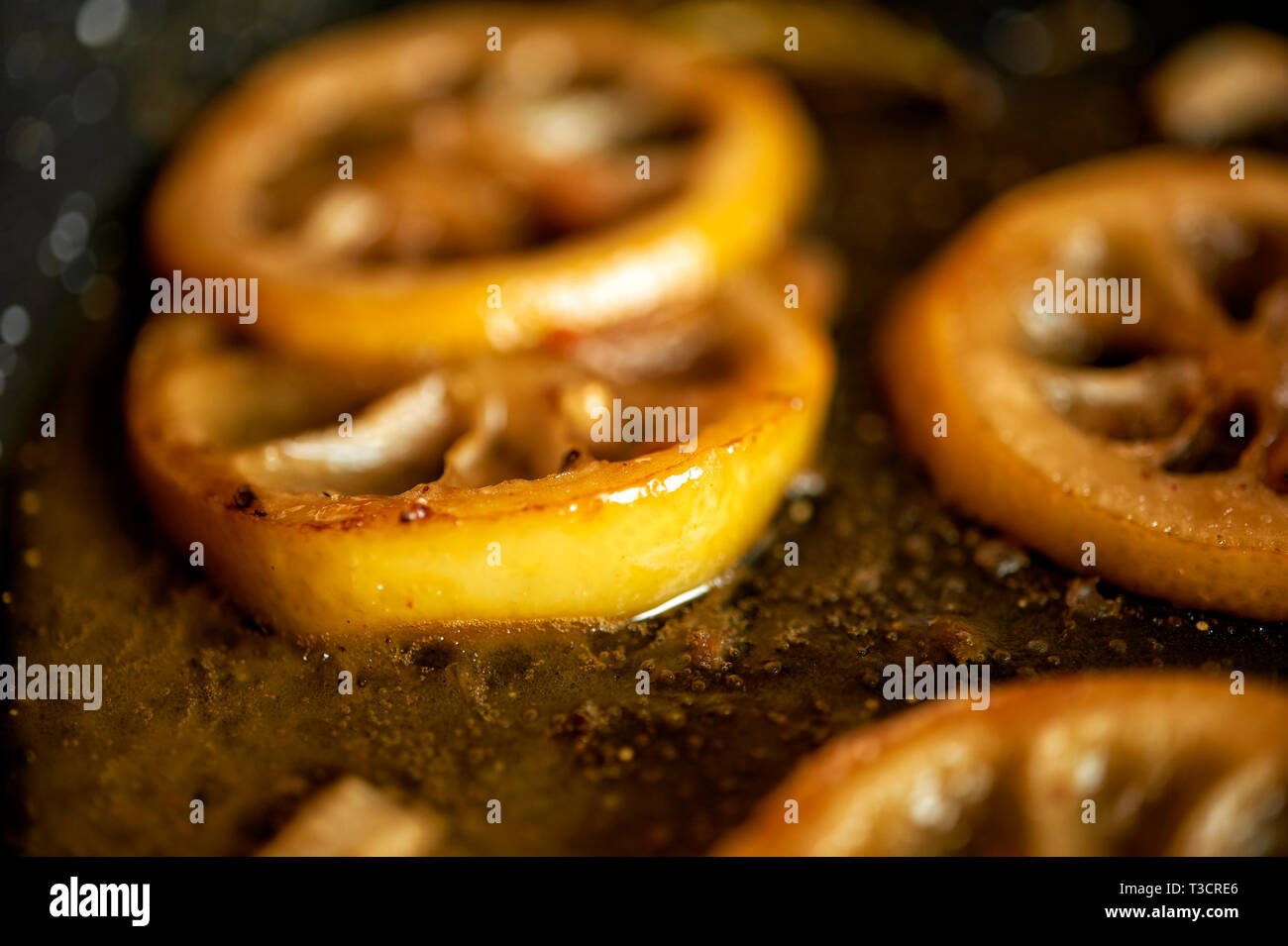 In einer Pfanne liegen in Butter angebratene Zitronenscheiben für ein Gericht zubereitet um frische Saeure zu erhalten. Stock Photo