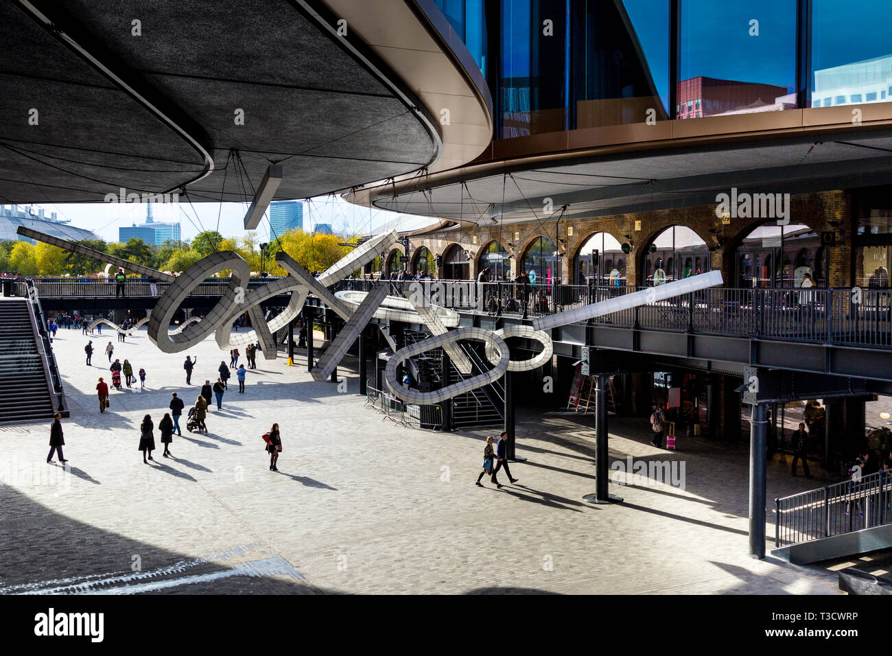 People shopping in Coal Drops Yard and a giant suspended sculpture 'Space Frames' by Studio Mieke Meijerin in Kings Cross, London, UK Stock Photo