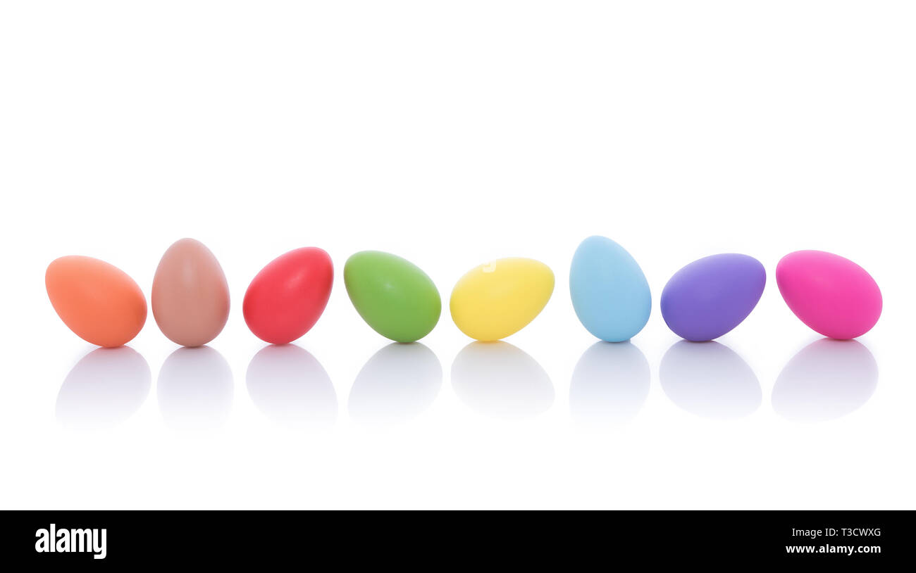 Bright colorful Easter eggs lined up in a row on a white background Stock Photo