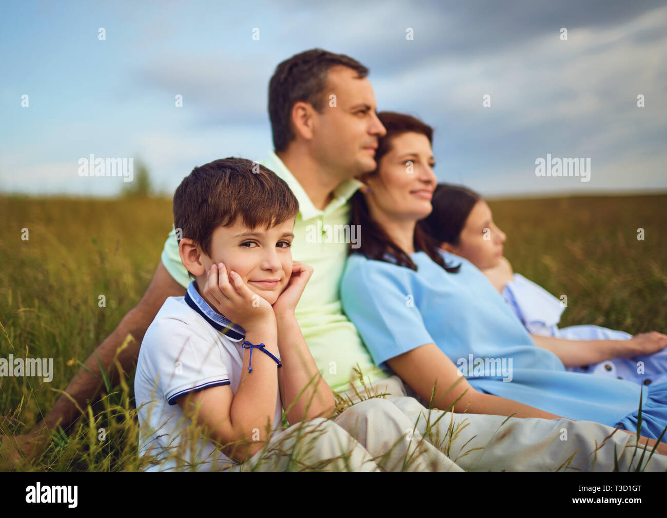 Family resting together sitting on grass in nature Stock Photo - Alamy